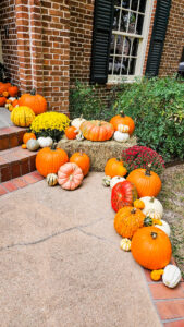 pumpkin decoration ideas on fall porch with hay bales and colorful pumpkins